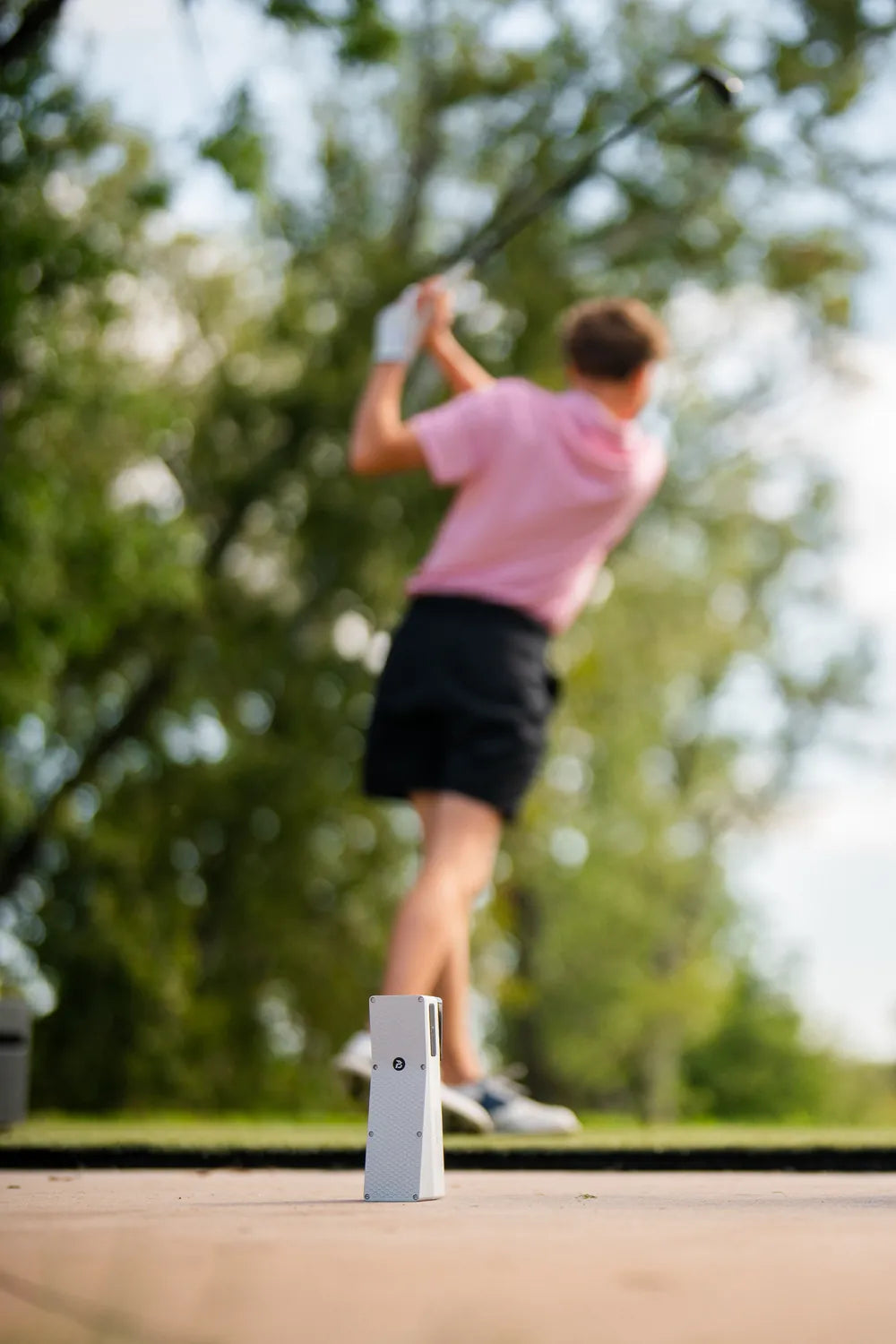Golfer mid swing with the X10 behind her
